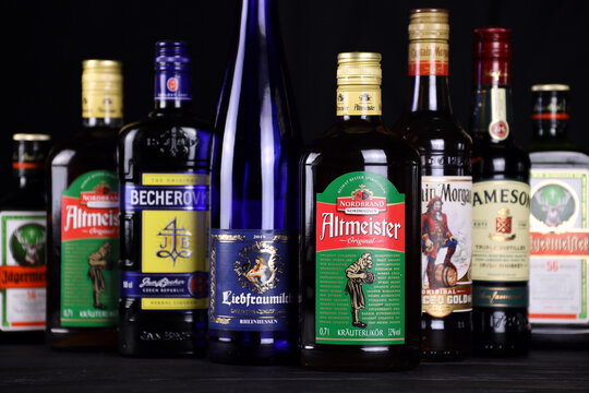 KHARKOV, UKRAINE - DECEMBER 3, 2020: Many famous branded alcohol bottles and glass with whisky drink on dark black background. Elite alcohol