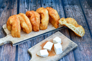 Traditional Bulgarian home made deep fried  patties  covered with sugar  оn rustic backgroud.Mekitsa or Mekica,  on wooden  rustic  background. Made of kneaded dough that is deep fried 