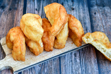 Traditional Bulgarian home made deep fried  patties  covered with sugar  оn rustic backgroud.Mekitsa or Mekica,  on wooden  rustic  background. Made of kneaded dough that is deep fried 