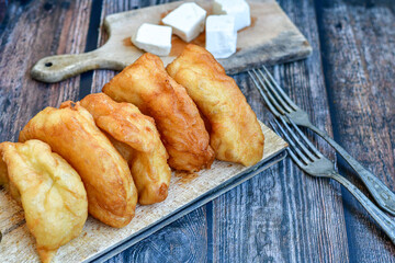 Traditional Bulgarian home made deep fried  patties  covered with sugar  оn rustic backgroud.Mekitsa or Mekica,  on wooden  rustic  background. Made of kneaded dough that is deep fried 