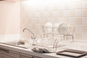kitchenware with clean dishes and silver sink in the white kitchen