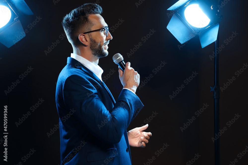 Wall mural motivational speaker with microphone performing on stage. space for text