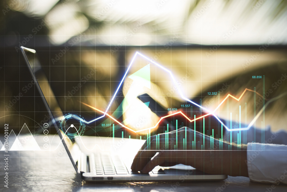 Poster close up of businessman hands using laptop and smartphone with creative glowing forex graph on blurr