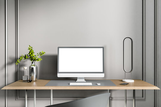 Close up of creative designer desktop with clean white computer screen, keyboard, decorative plant and other items on concrete wall background. Workplace concept. Mock up, 3D Rendering.