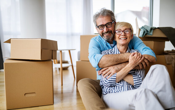 Portrait of happy senior couple in love moving in new home - Powered by Adobe