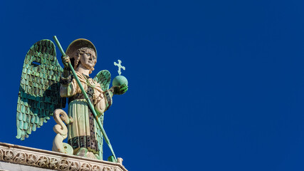 Saint Michael the Archangel defeats the Dragon, a medieval 13th century statue a the top of St...