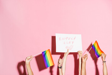Young three women showing placard and rainbow flags
