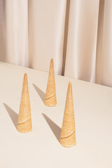 Minimal modern summer composition with three ice cream cones on stylish silk background. Trendy retro concept.