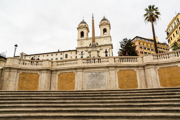 Fototapeta na wymiar Trinita dei Monti church with Spanish Steps in foreground in a rainy day, Rome, Italy
