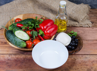 Ingredients for Greek salad preparation and empty bowl