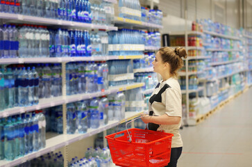 Woman choosing a dairy products at supermarket.woman choosing a bottle of water in a supermarket