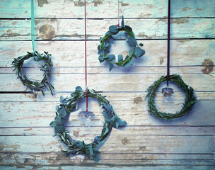 Advent wreaths hanging from strings on wooden wall