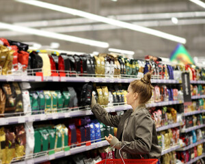 Woman choosing a dairy products at supermarket.choosing coffee in supermarket