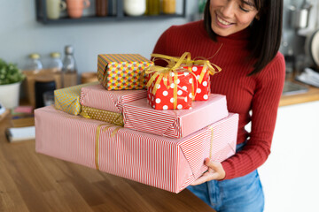 Young freelancer carrying gift boxes at home
