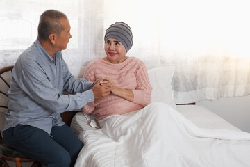 couple senior asian woman is chemotherapy and retirement man is encouragement on the bed