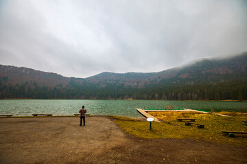 Tourist taking pictures of the landscape with St. Anne's Lake, Lake in Transylvania, Romania