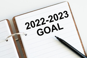 Notepad with text 2022-2023 target next to black marker. Risk Management, Resolution, strategy, solution, goal, New Year New You and happy holiday concepts