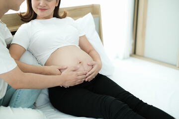 portrait asia young pregnant woman and husband happy together on the bed