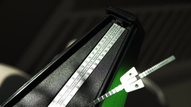 Vintage metronome with golden pendulum beats slow rhythm