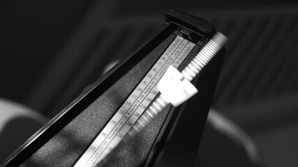 Vintage metronome with golden pendulum beats slow rhythm