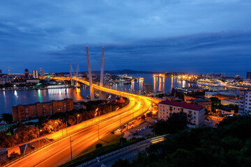The Golden Bridge in Vladivostok over the Golden Horn Bay in the evening. Panoramic shooting.