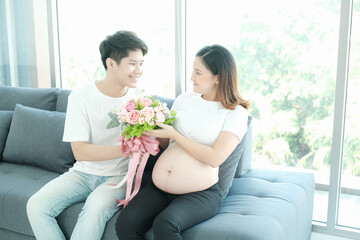 Fototapeta na wymiar portrait asia young pregnant woman and husband happy together on sofa