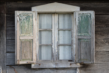 Sunja,Croatia,05,04,2021. Rustic style aged window in wooden village rural home wall.