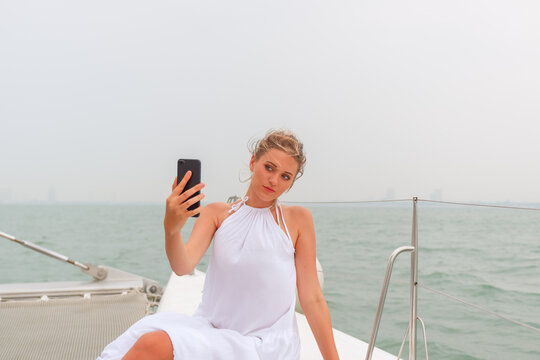 Caucasian woman on luxury yacht with smart phone