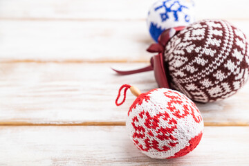 Christmas or New Year composition. Decorations, knitted balls, on a white wooden background. Side view, copy space.