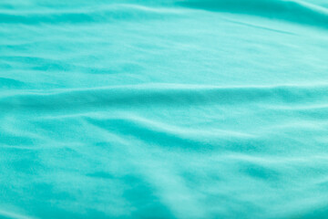 Fragment of smooth silk blue tissue. Side view, natural textile background.