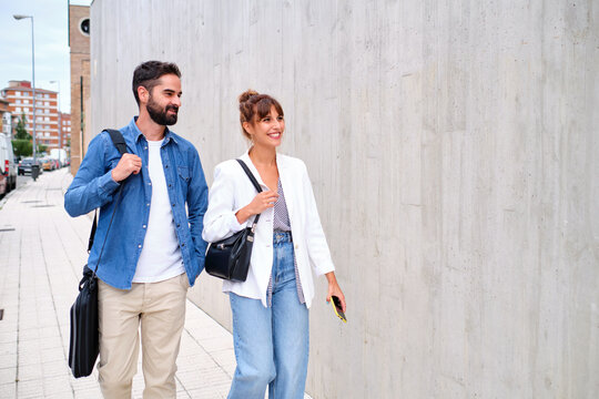 Two Co-workers Walking Home After A Day's Work Walking Down The Sidewalk