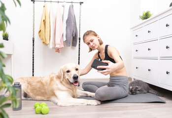 Girl takes a selfie with her dog while doing yoga at home