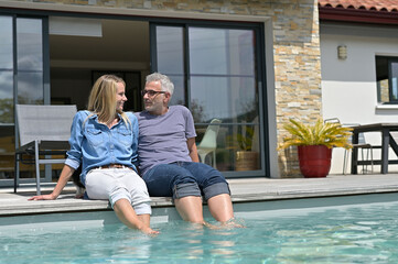 Middle-aged couple enjoying time by private pool