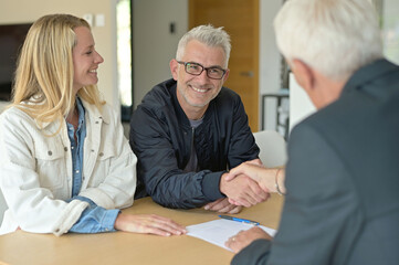 Obraz premium couple signing contract with real estate agent