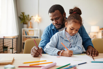 Naklejka premium Portrait of African-American man with little girl drawing together at home, copy space
