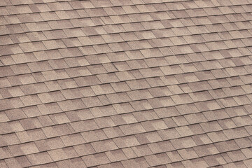 brown roof shingles background and texture. dark asphalt tiles on the roof.Perspective view.
