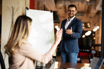 Businessman present his idea to working team. Young handsome man presenting businessplan