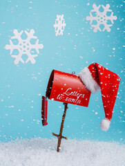 Santa's mailbox with snowflakes falling isolated on a bright blue background. Creative Xmas and New Year celebration concept. Winter holiday wishes and presents.