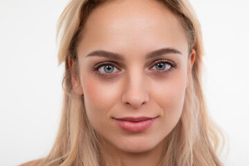 Obraz premium close-up portrait of a young blonde on a white background looking at the camera