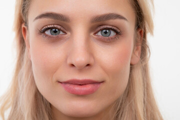 Fototapeta premium close-up portrait of a blonde of European appearance on a white background looking at the camera with a slight smile on her face