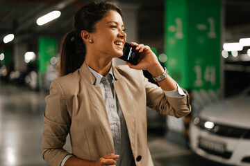 Businesswoman in suit unlocking car on parking. Beautiful woman talking to the phone