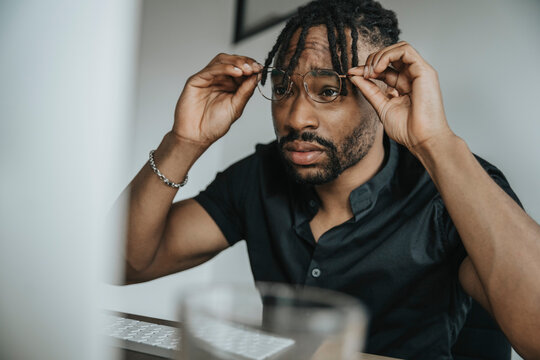Businessman looking at computer through eyeglasses in office