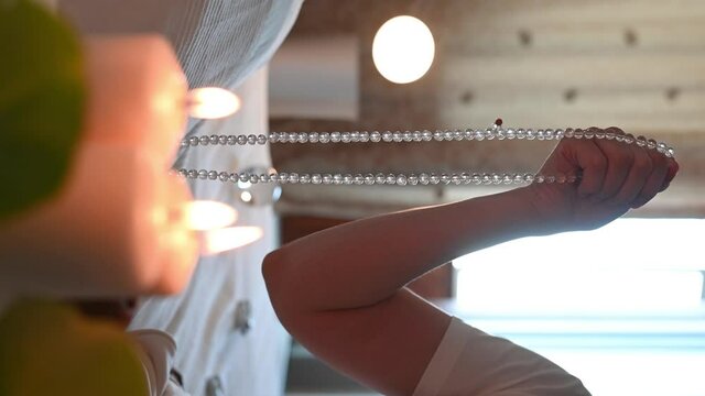 vertical video. a man sits in a lotus position. close-up of hands fingering rosary. isoteric theme. High quality 4k footage