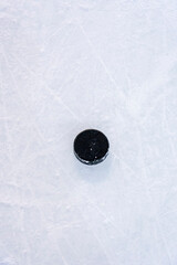 Clean empty ice hockey rink. Skate blade marks and snow crumbs. There is old playing puck on...