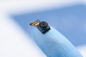 Camera module on fingertip. Smartphone cell phone small camera sensor with high resolution,...
