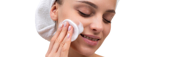 woman after shower with a cotton pad apply cream on her face skin care at the age of 30 plus