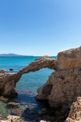 natural arch of portitxol on the costa brava with a tourist swimming a sunny summer day