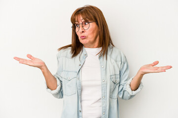 Middle age caucasian woman isolated on white background confused and doubtful shrugging shoulders to hold a copy space.