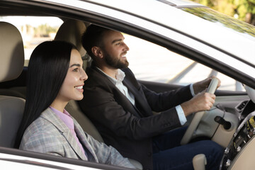 Young woman and driver in modern car