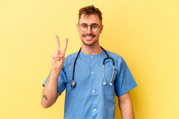 Young nurse caucasian man isolated on yellow background showing number two with fingers.